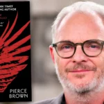 کتاب رد رایزینگ (Red Rising) اثر نویسنده پیرس براون (Pierce Brown) در کنار چهره او